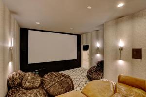 a movie room with a large screen in the wall at Contemporary Wyoming Luxury in Sheridan +2 photos