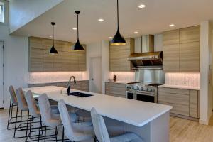 a kitchen with a large white island with chairs at Contemporary Wyoming Luxury in Sheridan