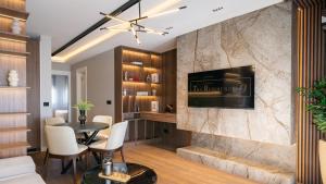 a living room with a table and a tv on a wall at The Residence 59 in Belgrade