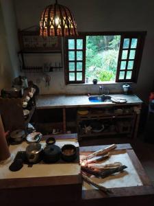 a kitchen with a table with pots and pans on it at Vila do Salitre - Casa a 5 min de lagos e cachoeiras in Extração