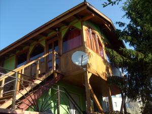 Una casa en el árbol con un balcón en el lateral. en Transylvania Cowboy Cottage, en Cluj-Napoca