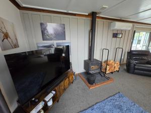 a living room with a flat screen tv and a wood stove at Fun For The Whole Family in Taupo