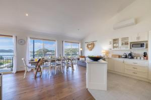 a kitchen and dining room with a table and chairs at Wanda Up, 80 Randall Dr - spectacular views, aircon and Wi-Fi in Salamander Bay