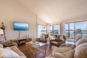 a living room with two couches and a tv at Wanda Up, 80 Randall Dr - spectacular views, aircon and Wi-Fi in Salamander Bay