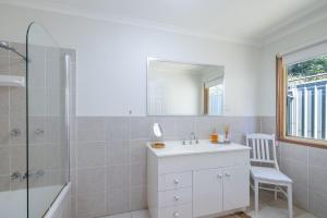a bathroom with a sink and a shower and a mirror at Wanda Up, 80 Randall Dr - spectacular views, aircon and Wi-Fi in Salamander Bay +23 photos