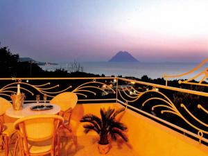 einen Balkon mit einem Tisch und Stühlen sowie Meerblick in der Unterkunft Blu Tropical Resort in Zambrone