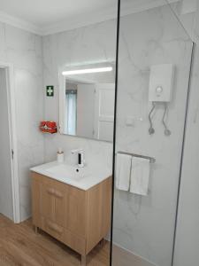 a bathroom with a sink and a mirror at Casa Cayenne in Ponta Delgada +17 photos