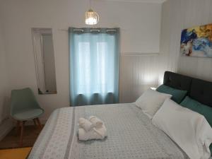 a bedroom with a bed with a towel on it at Casa Cayenne in Ponta Delgada