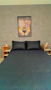 a bedroom with a bed with a painting of a tiger at Casa Fabluys 3 in Florianópolis