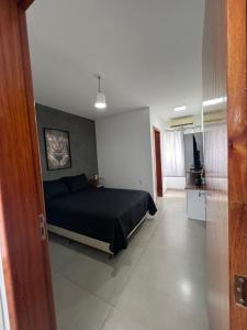 a bedroom with a black bed in a room at Casa Fabluys 3 in Florianópolis