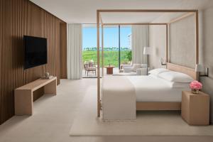 a hotel room with a bed and a living room at The Riviera Maya EDITION at Kanai in Playa del Carmen