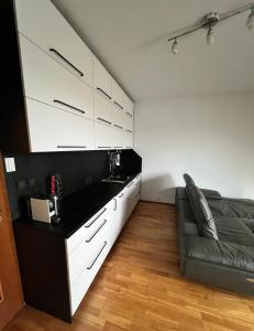 a room with a bed and white cabinets and a couch at Mattioliho Apartment in Prague