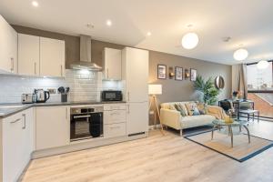 a kitchen and living room with a couch and a table at City Centre Birmingham 1-Bed with WiFi and Parking in Birmingham