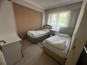 KarabükSafranbolu apartments的一间小房间，里面有两张床和一个窗户。