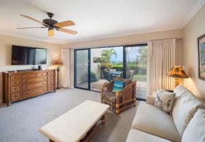 a living room with a couch and a tv at Ho'omaha - Serene Kihei Condo in Maui Kamaole for Ocean Views and Relaxation in Wailea