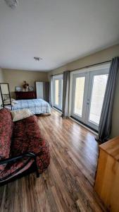 a living room with a bed and a wooden floor at Spacious West Kelowna Home that is great for family, friends, or business trip! in West Kelowna +6 photos