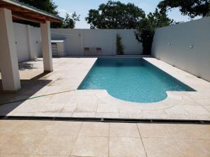 a swimming pool in a backyard with a white fence at Lorelei in Mina Clavero