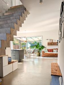 an open kitchen and living room with a staircase at Architektenhaus mit Spielplatz, Sauna & Pool am Wald nahe Hamburg in Siedlung Hainbuch +42 photos