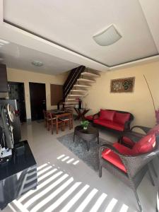 un salon avec un canapé rouge et des chaises dans l'établissement Tagaytay Hampton Villa, à Tagaytay