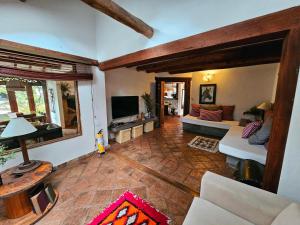 a living room with a couch and a tv at Casa Jequeneque in Villa de Leyva
