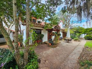 a house with a patio and a table and a umbrella at Casa Jequeneque in Villa de Leyva