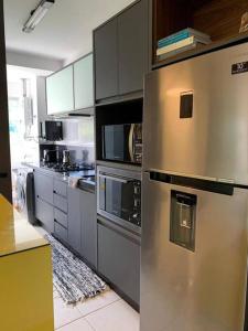 a kitchen with a stainless steel refrigerator and cabinets at o MELHOR DA PRAIA BRAVA !!! in Itajaí