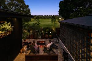 a group of people sitting on a patio with a fireplace at The Bangalow Barn in Bangalow