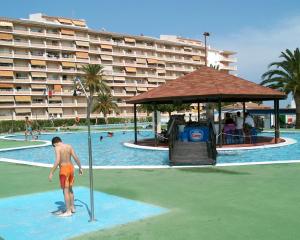 a man standing next to a pool in a resort at Alpen1 Peñismar I in Peniscola