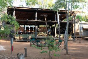 a building with tables and chairs in a park at Mitchell Falls Wilderness Lodge in Camp Creek