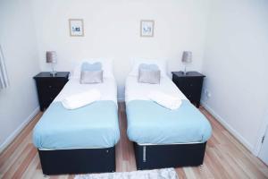 two beds in a room with two night stands at StayNorwich 69G - Hush View House in Romford