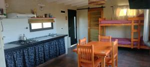 cocina y comedor con mesa y litera en El Colibrí de los Molles, en Los Molles