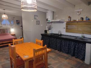 Una cocina y un comedor con una mesa y un fregadero. en El Colibrí de los Molles, en Los Molles