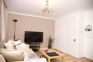 a living room with a couch and a tv at StayNorwich 69G - Hush View House in Romford