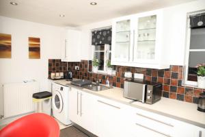 a kitchen with a sink and a washing machine at StayNorwich 69G - Hush View House in Romford +19 photos