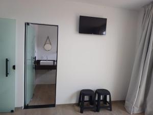 deux tabourets noirs dans une pièce avec un miroir dans l'établissement Casa El Badan Olímpia Thermas dos Laranjais Roma, à Olímpia