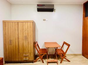 a room with a table and two chairs and a cabinet at Habitación Céntrica en Iquitos - Casa Alemi in Iquitos