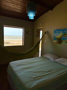 a bedroom with a bed with a view of the beach at Casa do Pescador - Praia do Maceió - Camocim - CE in Camocim