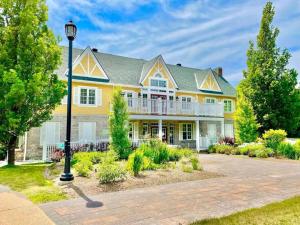 a large yellow house with a porch at Country Retreat Horseshoe Valley in Shanty Bay