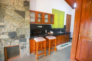 a kitchen with wooden cabinets and a counter with a sink at The Green Lush in Pussellawa