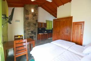a bedroom with a bed and a table and a desk at The Green Lush in Pussellawa