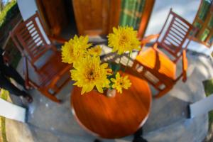 a vase filled with yellow flowers on a table at The Green Lush in Pussellawa +24 photos