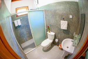 a bathroom with a shower and a toilet and a sink at The Green Lush in Pussellawa