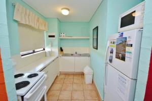 eine kleine Küche mit einem weißen Kühlschrank und einer Spüle in der Unterkunft Riverview Holiday Apartment 25 - Kalbarri, WA in Kalbarri