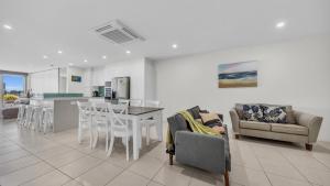 a kitchen and living room with a table and chairs at Waterfront On Market in Merimbula