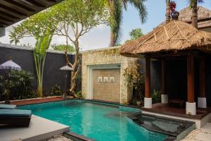 a swimming pool in front of a villa at Bali Ula Villa in Nusa Dua