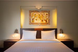 a bedroom with a bed with a painting on the wall at Bali Ula Villa in Nusa Dua +37 photos
