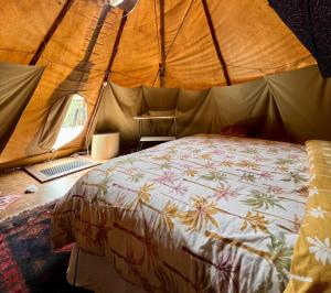 PuttyCosy Teepee to reconnect with Nature!的帐篷里有一张床的卧室