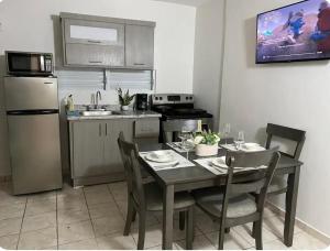 a kitchen with a table and chairs and a kitchen with a refrigerator at Shalex House 3 in Carolina
