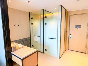 a bathroom with a glass shower and a sink at Four Points by Sheraton Datong Pingcheng in Datong