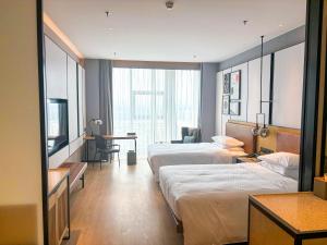 a hotel room with two beds and a desk at Four Points by Sheraton Datong Pingcheng in Datong